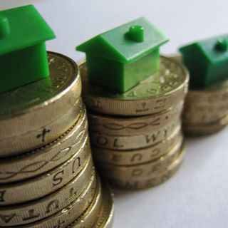coins with green plastic house and money