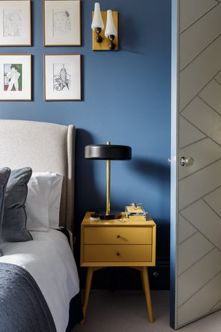 blue bedroom with yellow bedside table