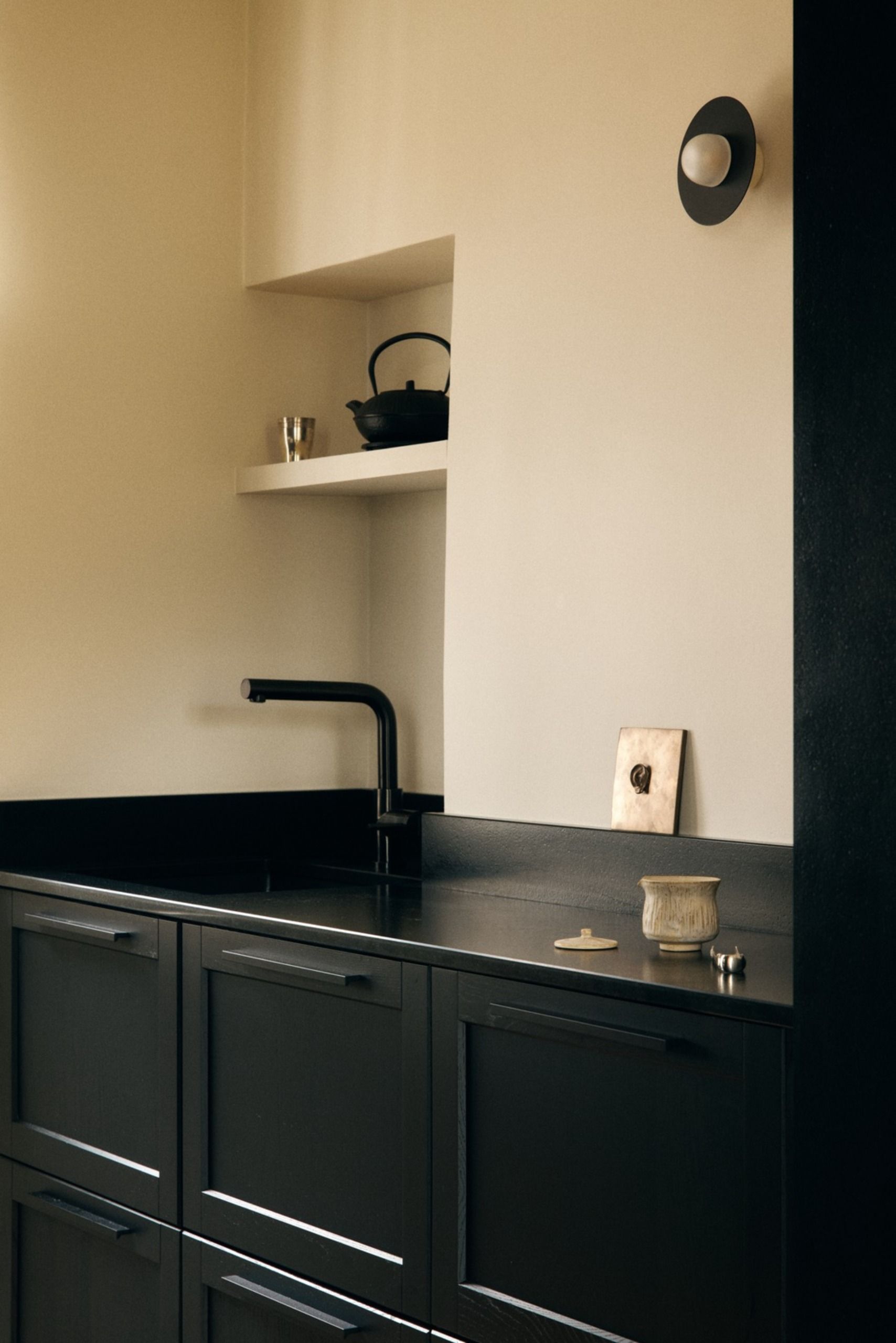 Small kitchen design with black door frame and black cabinets