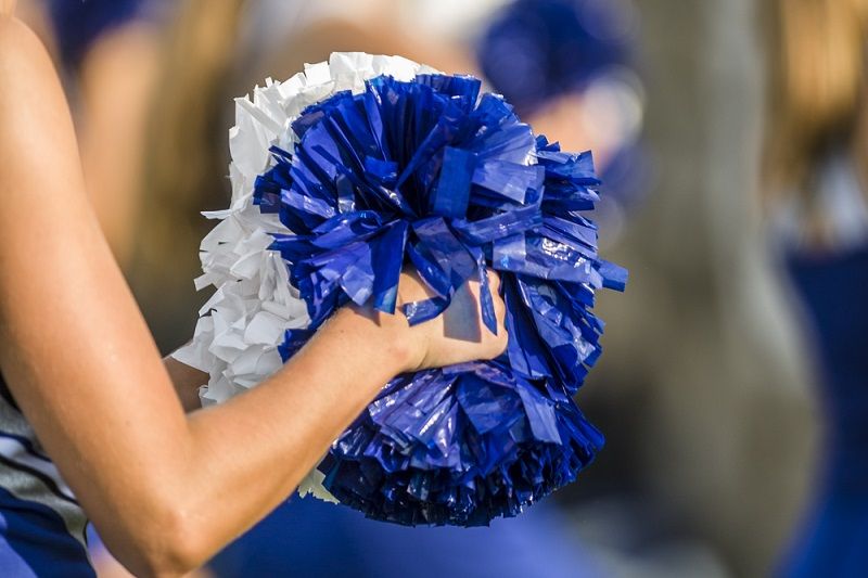 A cheerleader holding pom poms.