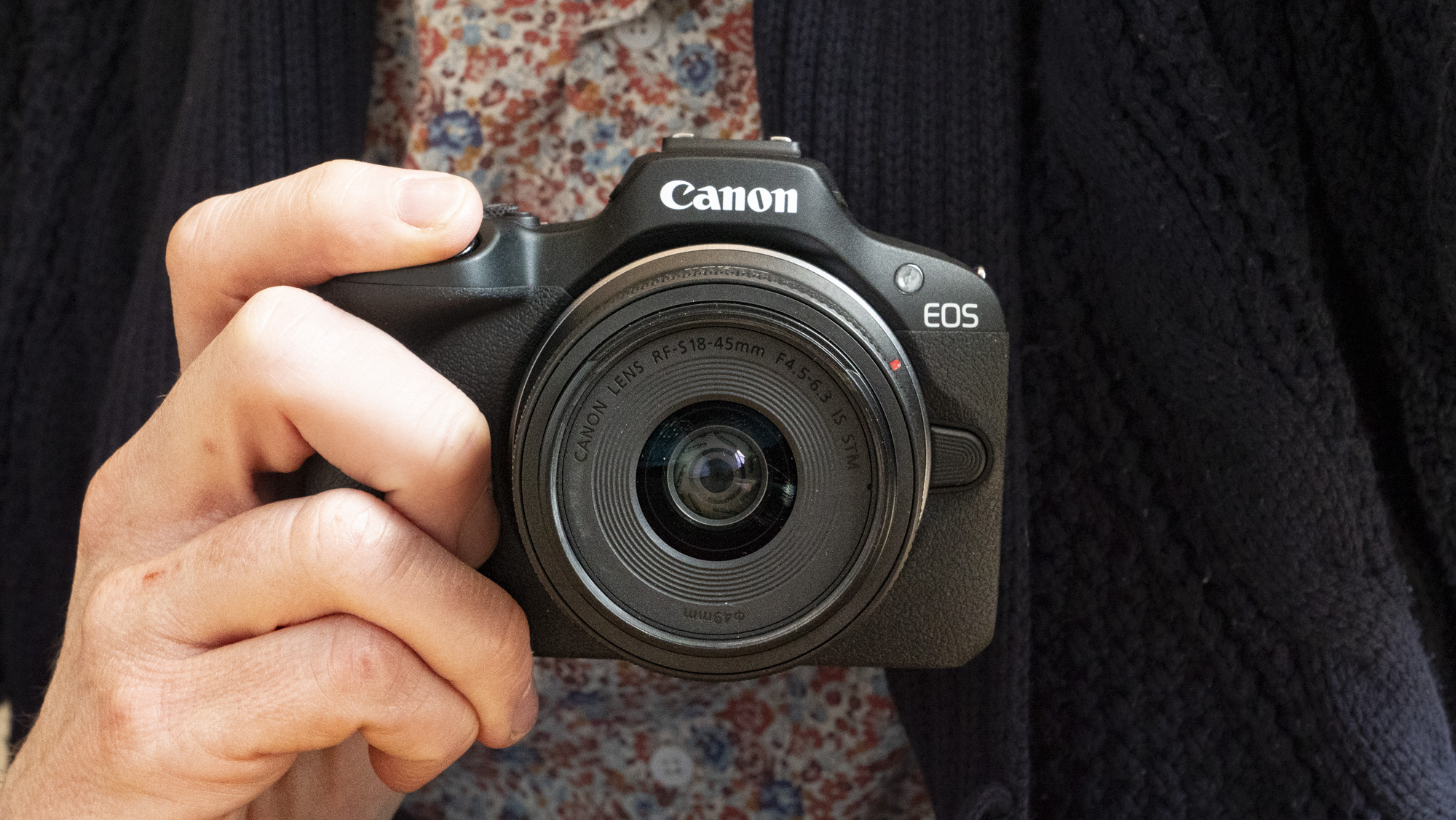 Canon EOS R100 camera in the hand