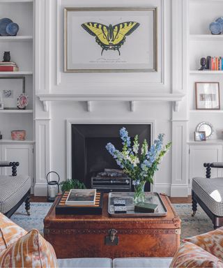 A butterfly artwork above a fire place in a white living room