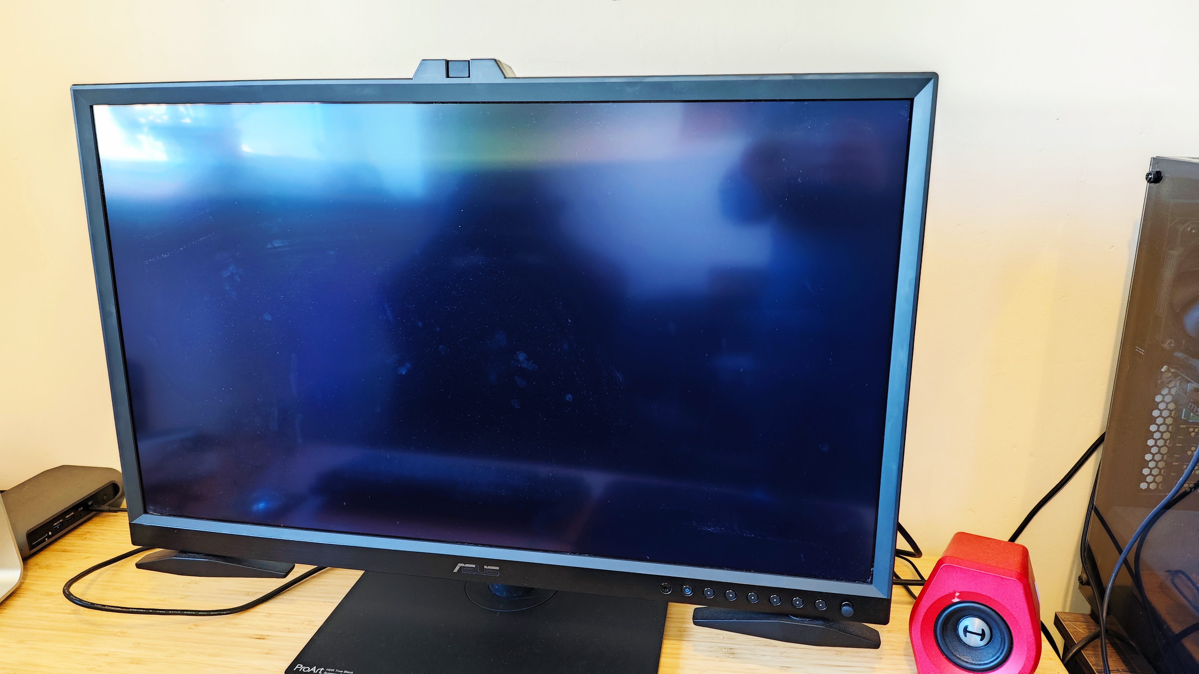 A black ASUS ProArt OLED PA32DC monitor sitting on a desk