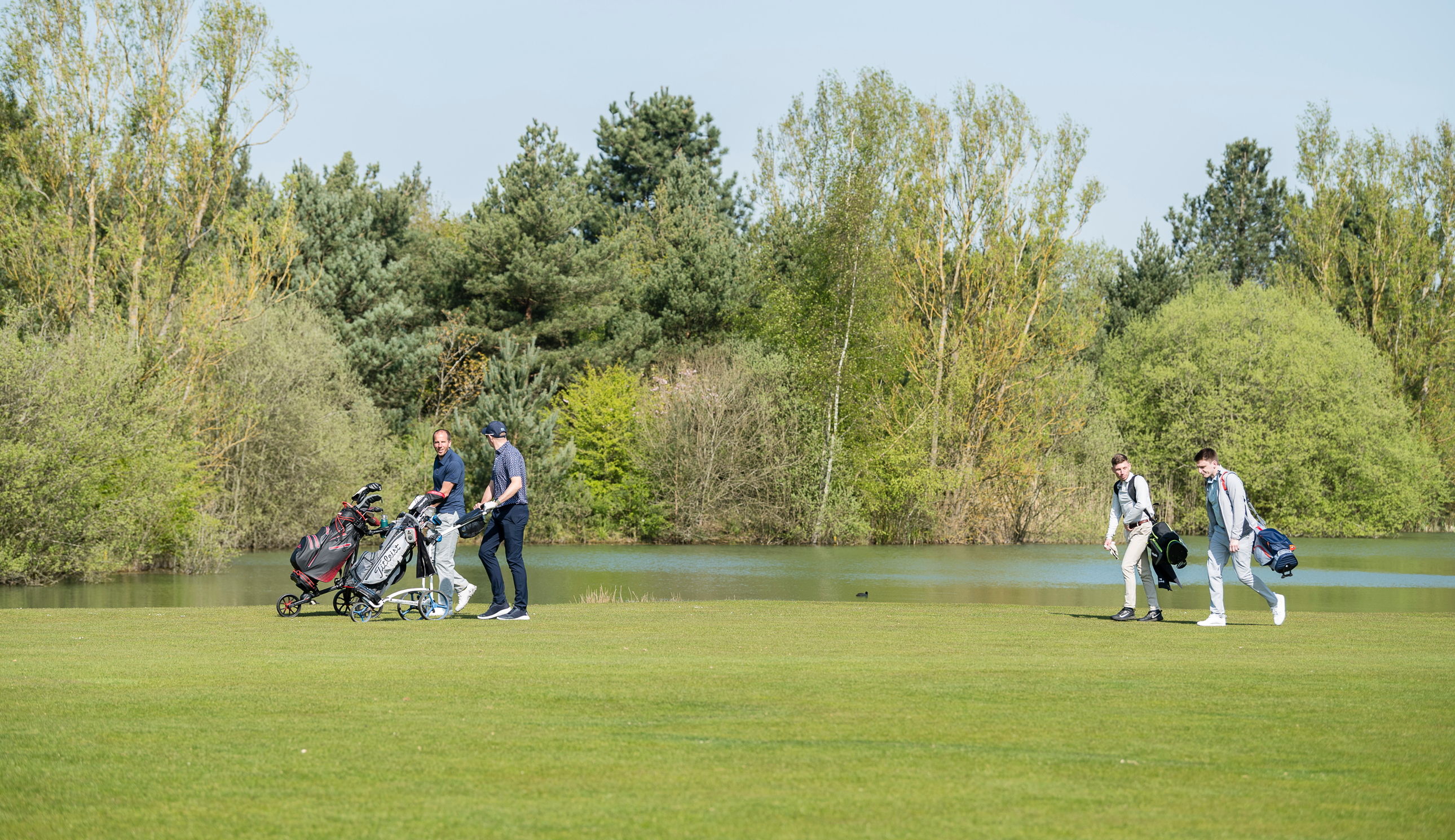 Golfers walk down the fairway