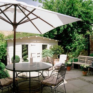 garden dining area with slate table and wire chair