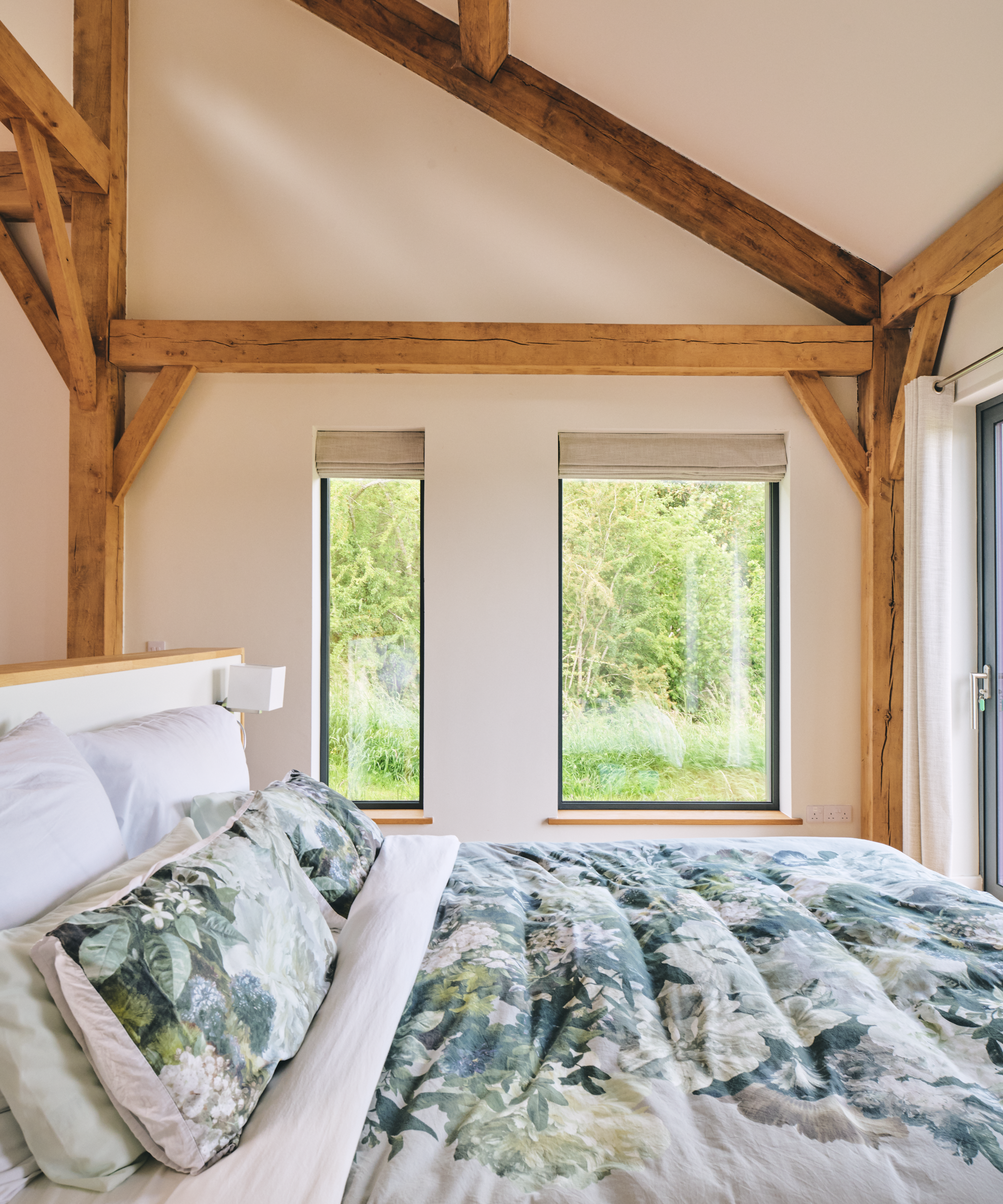 Bedroom with two windows overlooking greenery outside