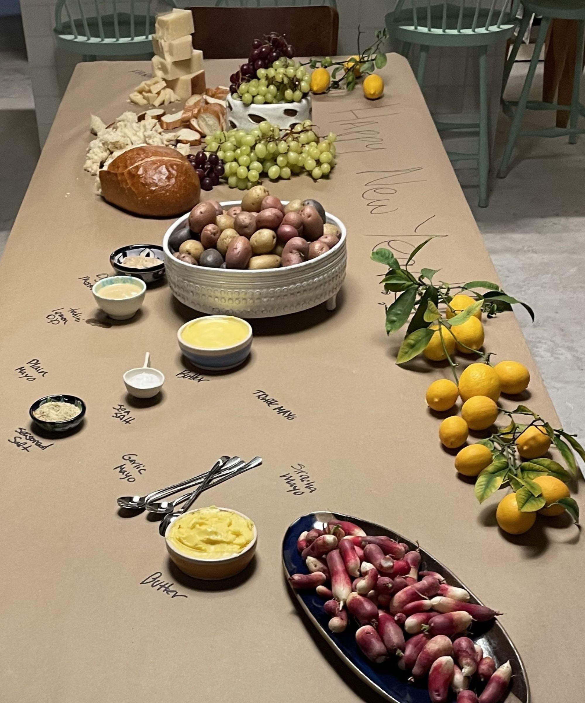 Brown paper table cloth with grazing dishes, bread, fruit and dips