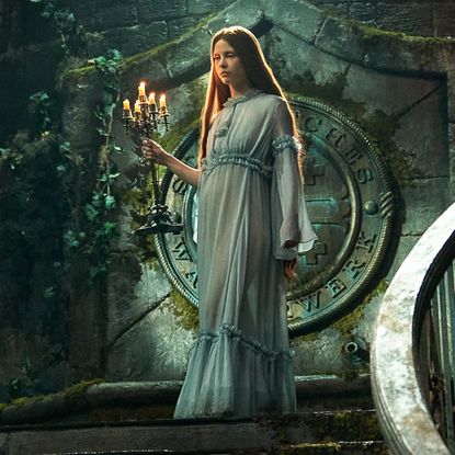 mia goth as elizabeth descending a staircase in a blue nightgown in frankenstein