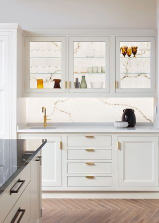 white kitchen with backlit wall behind cabinet