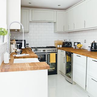 kitche3n with wooden worktop and white tiles