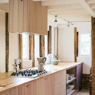 Wooden kitchen with no handles and white walls