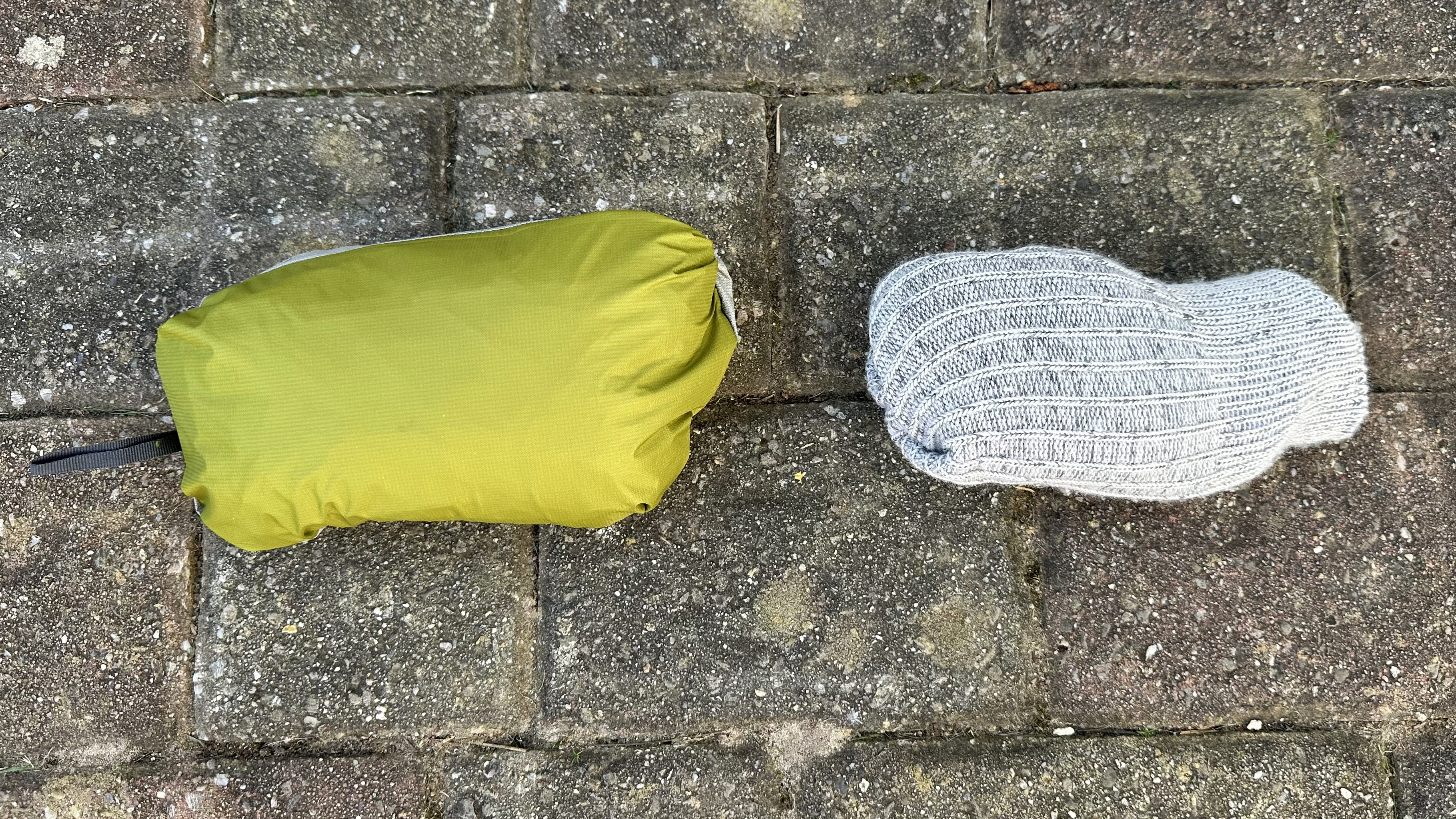 OR Helium UL jacket stashed in its pocket, next to a pair of hiking socks