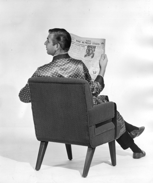 A gentleman in dressing gown and slippers reading the Sunday Times