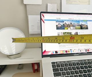 lumie dash on desk next to laptop with tape measure in shot showing how far away it is from the user