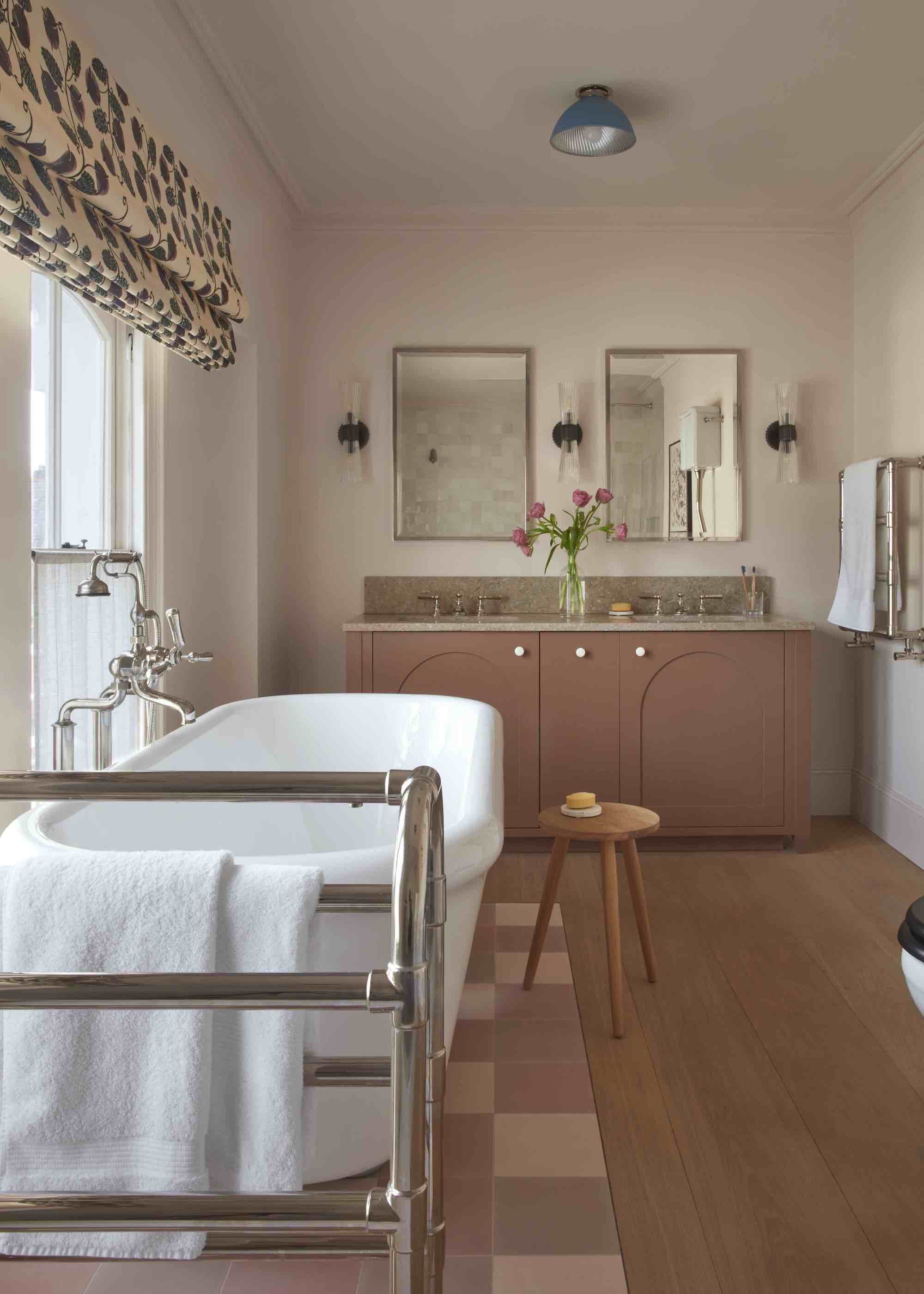 bathroom with a mix of tiled and wood flooring and a dark pink vanity and mirrors above the vanity