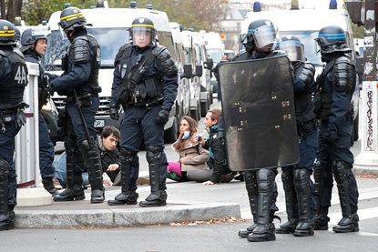 Police detain protesters at an environmental rally in Paris