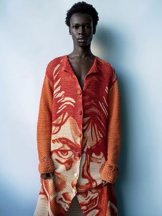 Orange cardigan with face print by JW Anderson
