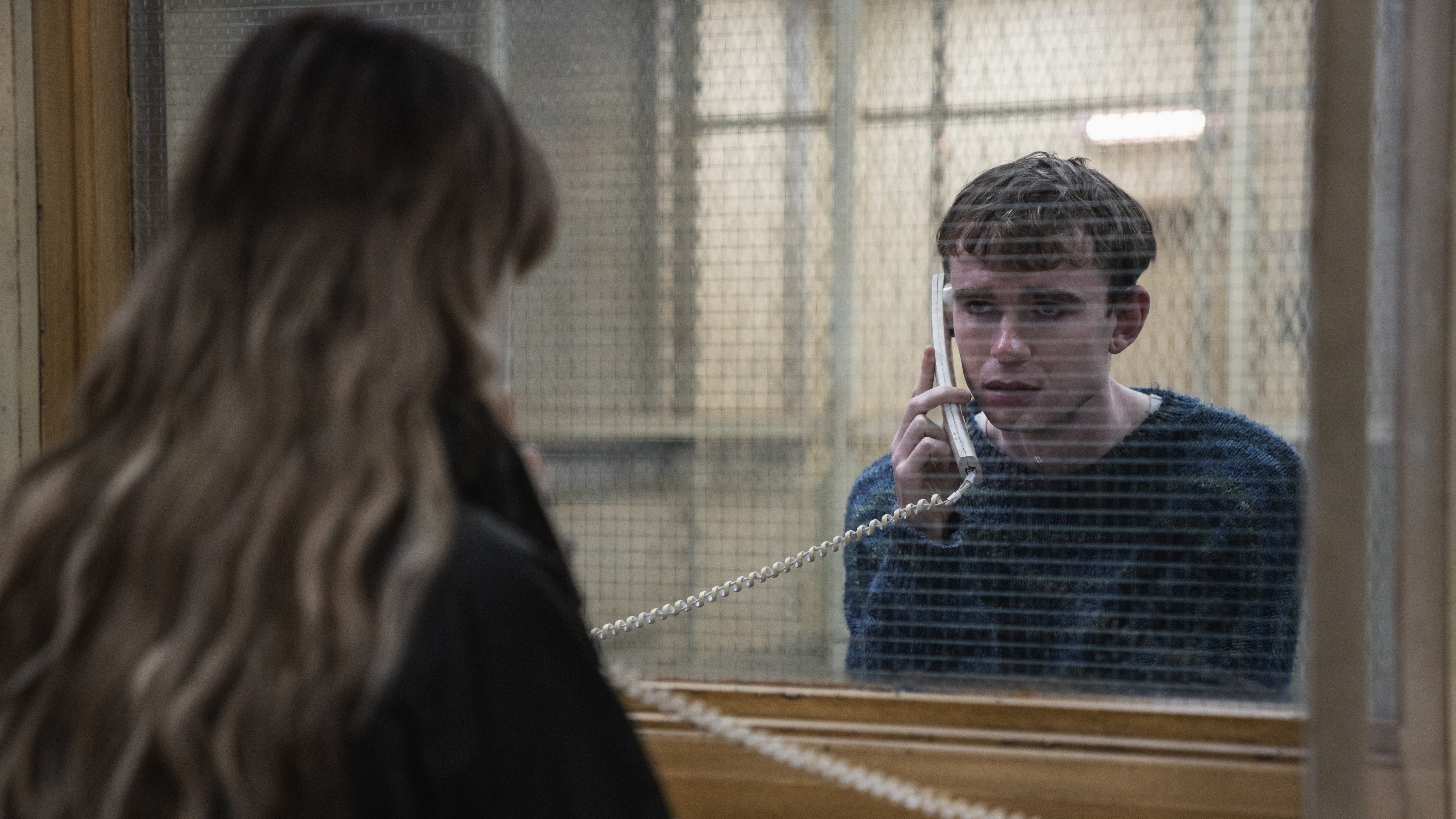 Jo talking to her son, Sonny, on a phone in prison while they look at one another through glass