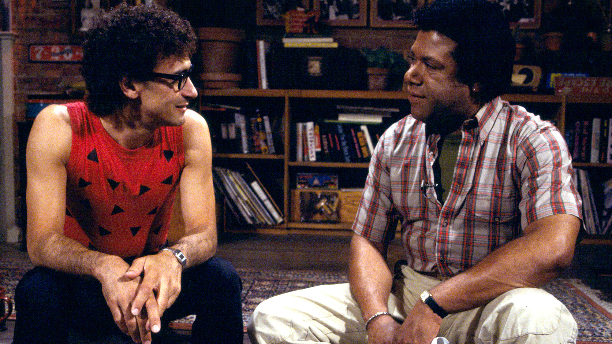 Donnie Iris (left) of Donnie Iris and the Cruisers, and MTV VJ JJ Jackson (1941 - 2004) as they sit on a low stage during an interview on MTV at Teletronic Studios, New York, New York, July 29, 1983.