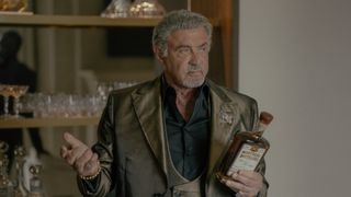 Dwight holds some alcohol in front of a bar in Tulsa King season 3