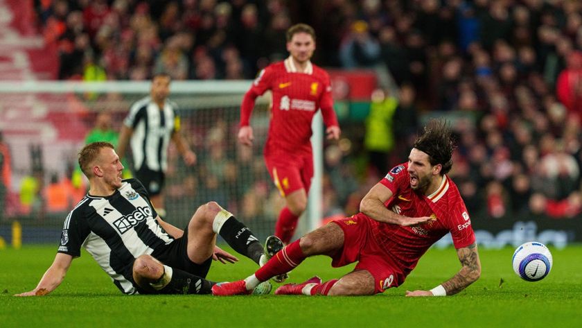 Newcastle United&#039;s Dan Burn battles with Liverpool&#039;s Dominik Szoboszlai during the Premier League match between Liverpool and Newcastle United at Anfield in Liverpool, England, on February 26, 2025.