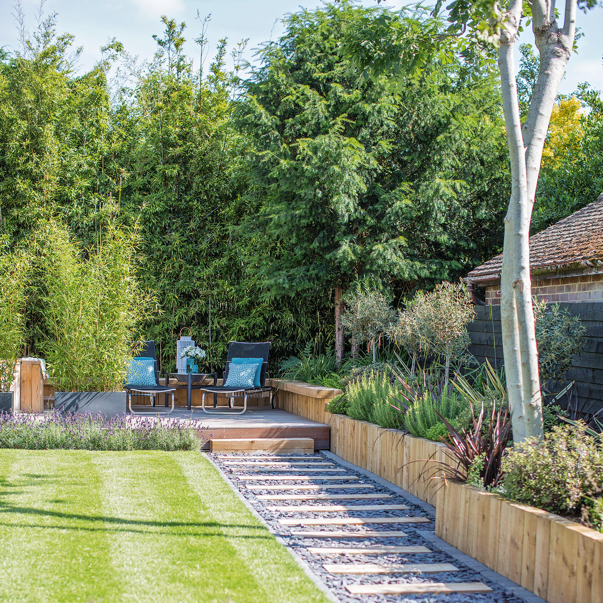 Garden with large lawn, pathway and trees around borders