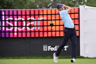 Jordan Spieth hits a drive in front of a Valspar Championship banner
