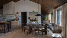 Open concept kitchen diner with a banquette dining space with gingham upholstered seating