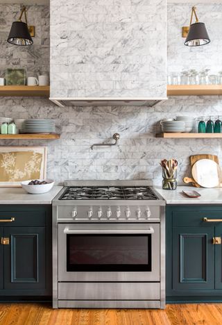 Kitchen with white marble tiles and dark green cabinetry