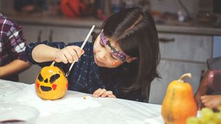 Halloween traditions with kids painting pumpkins