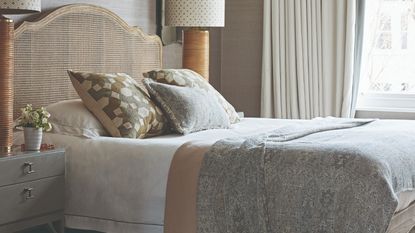 A bedroom with patterned bedding and two large matching table lamps