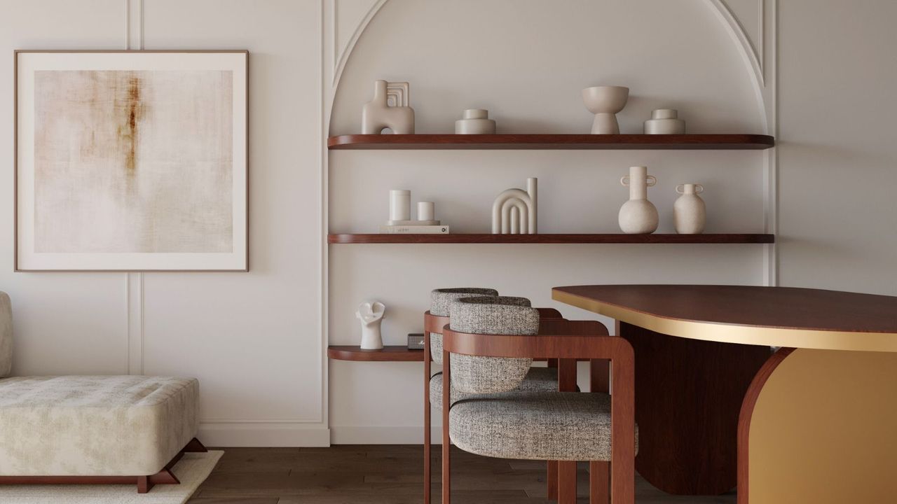 A white room with arced inset shelvig, neutral vases on display. A gold dining table and wood and grey upholstered chairs in front. A large square artwork hangs besides the shelves