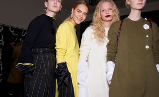 4 models wearing black with pin strip, yellow sweater, white dress, kaki sweater