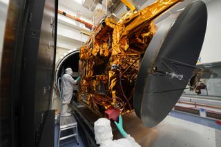 Engineers stand with the Hope Mars probe in a cleanroom.