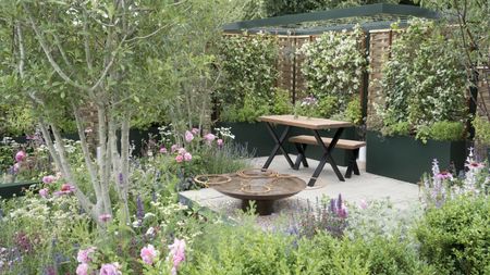 A modern garden with raised beds, trellises, and a patio with furniture