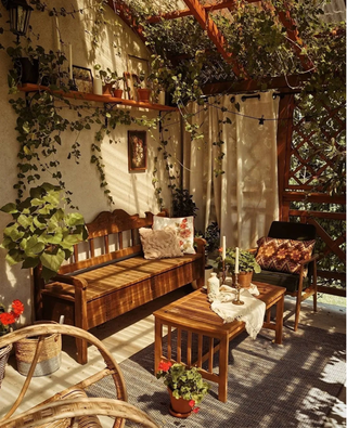 porch decor ideas with wood bench and table, candles on candlesticks and patterned cushions