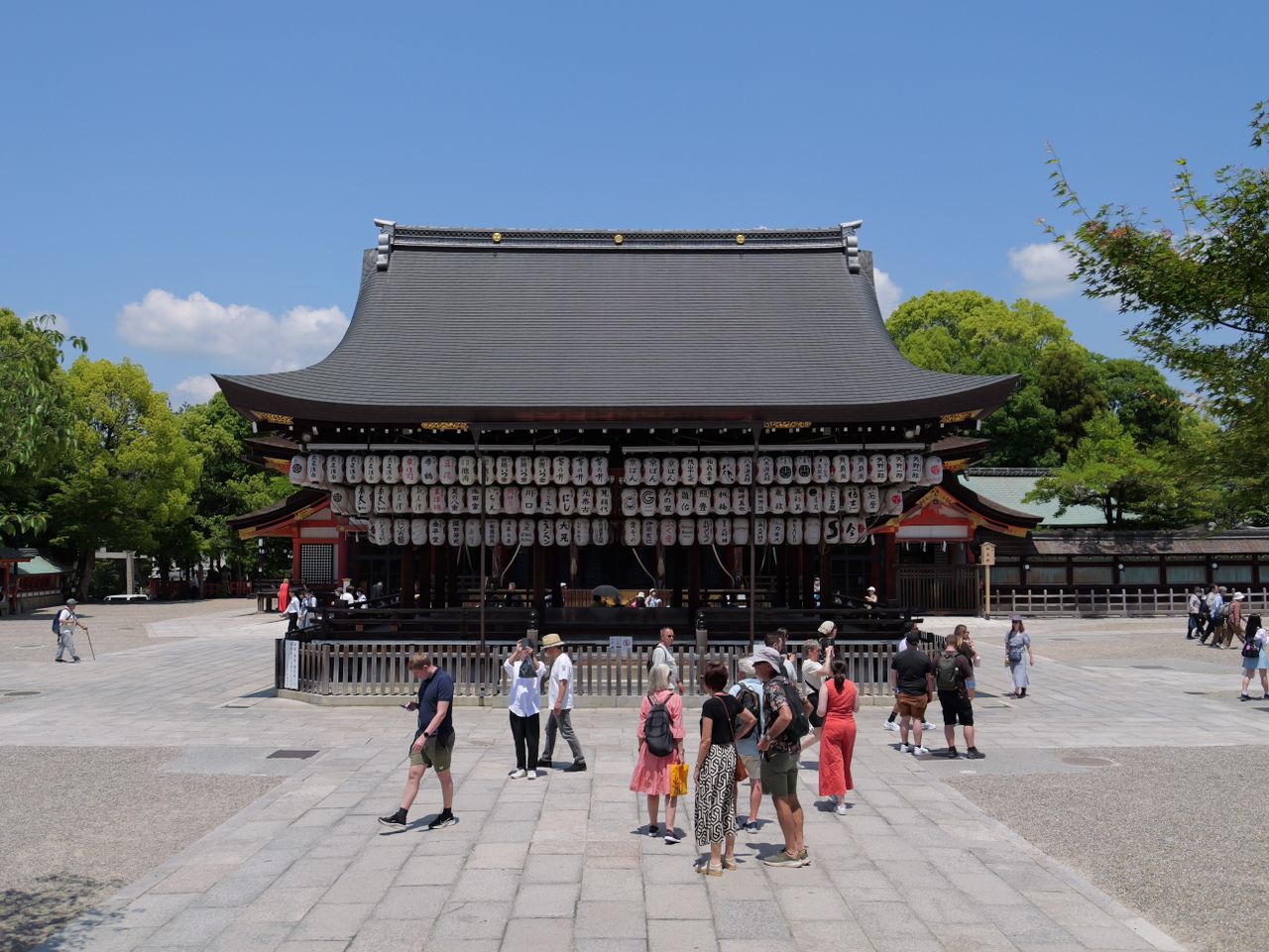 Temple building with lanterns and visitors in the courtyard.