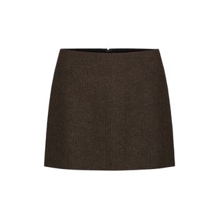 a Reformation tweed skirt in front of a white backdrop