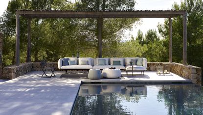 pool with paved deck, gazebo and sofa
