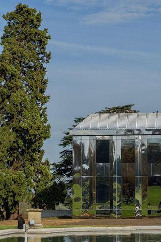 A close-up view of the château with trees reflected in its mirrored exteriror.