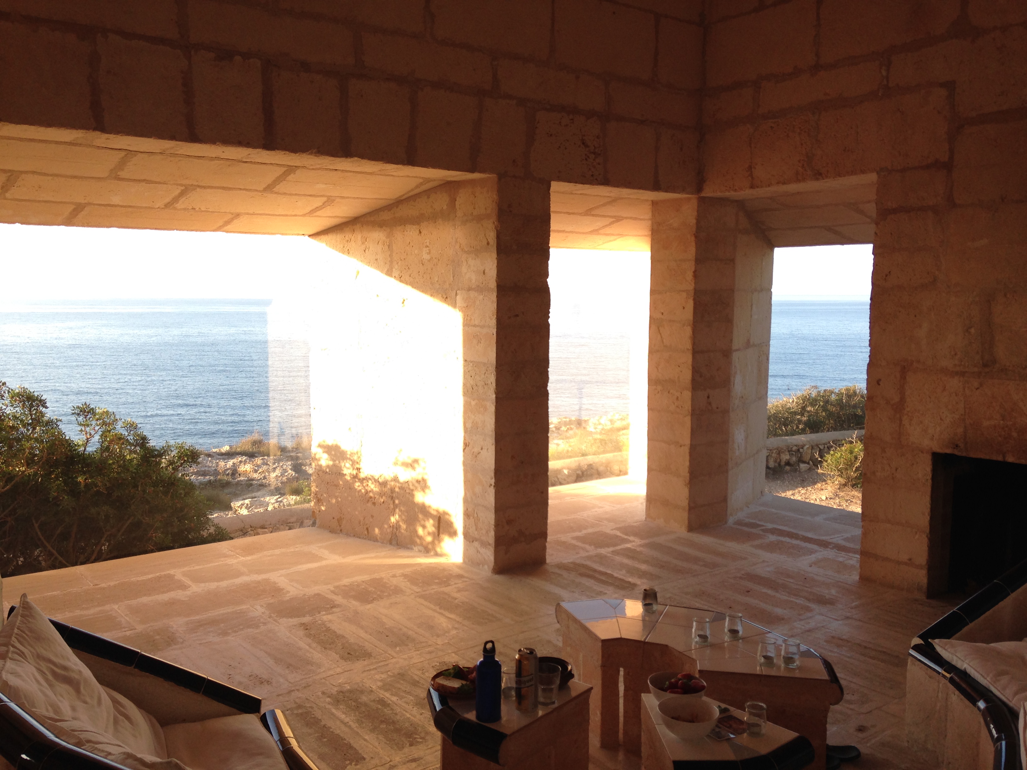 an image of the interior of Can Lis in Mallorca, looking out. Simple monolithic walls and a clean opening towards the sea