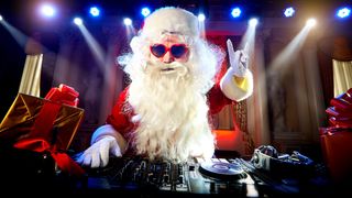 Santa behind DJ decks throwing the rock horns with his left hand