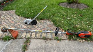 Husqvarna Combi Switch string trimmer and edger attachment on sidewalk next to lawn