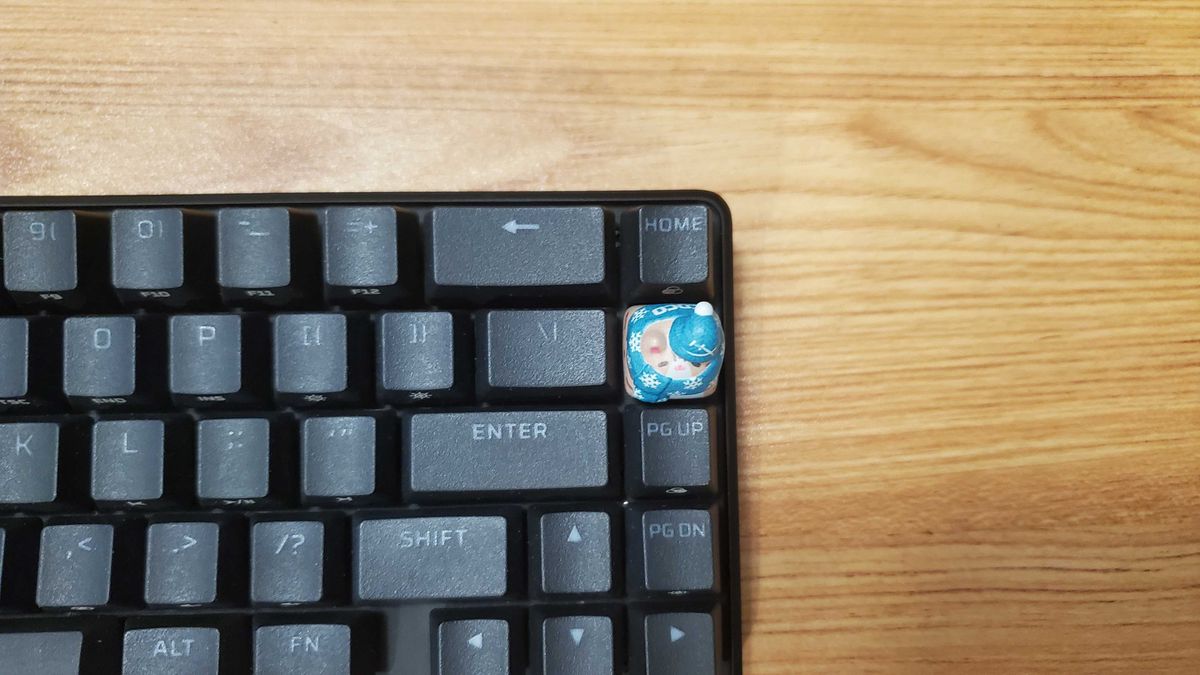 a small cat shaped keycap on a black keyboard