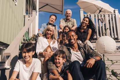 Family sitting on the steps of a beach house.