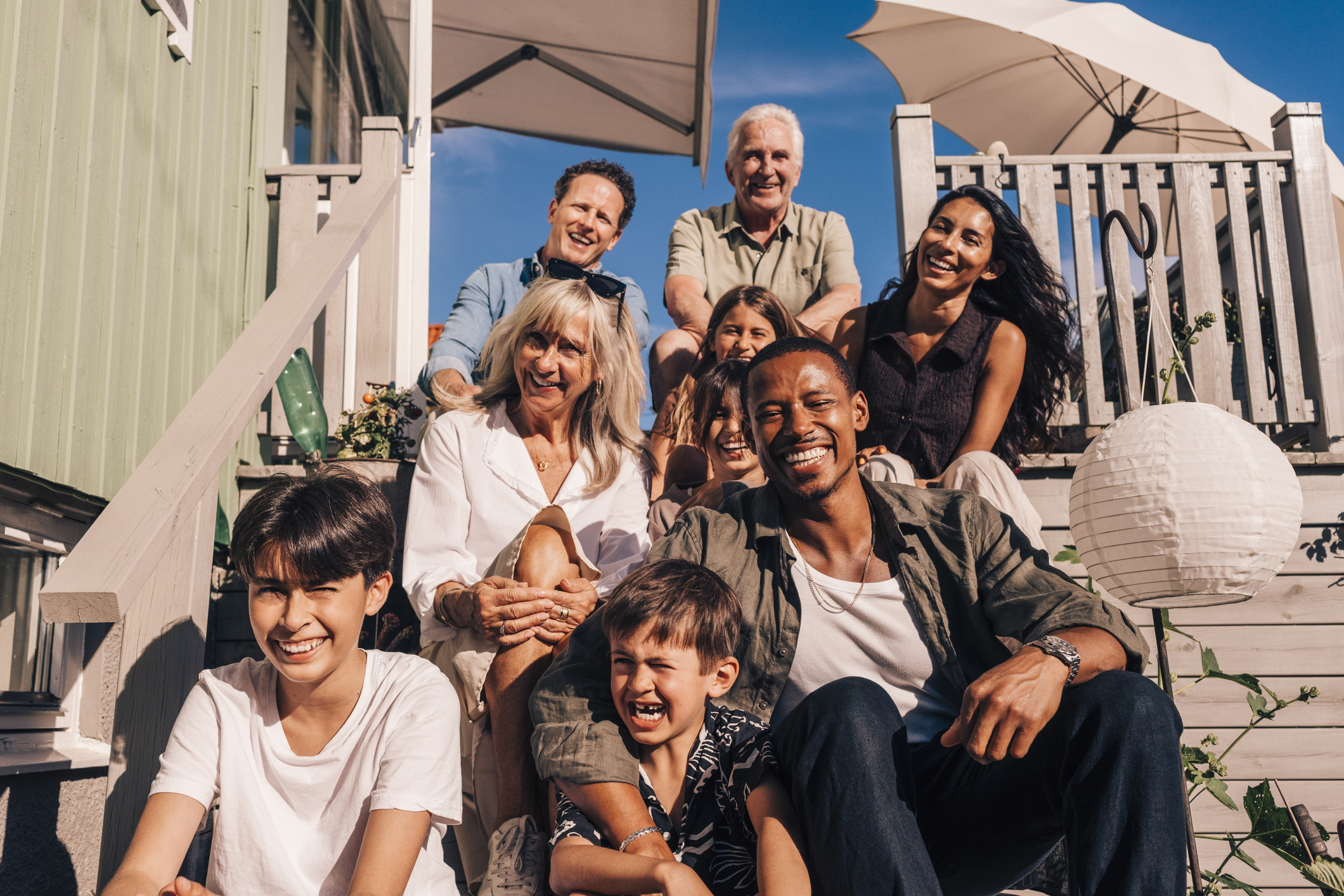 Family sitting on the steps of a beach house.