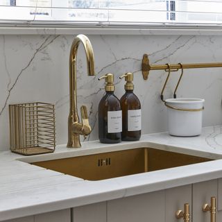 Kitchen sink in brass with matching tap and marble worktop