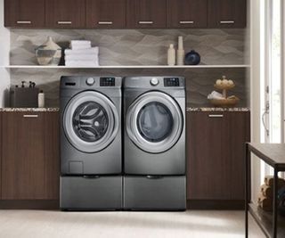 A washer dryer in a wood paneled laundry room