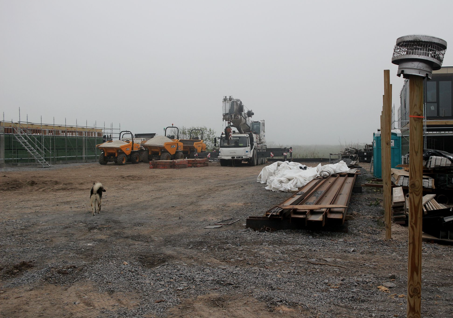 construction vehicles and materials on a bare plot of land