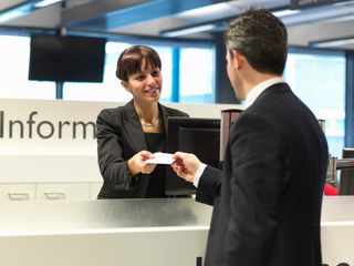 Receptionist talking to businessman at the airport